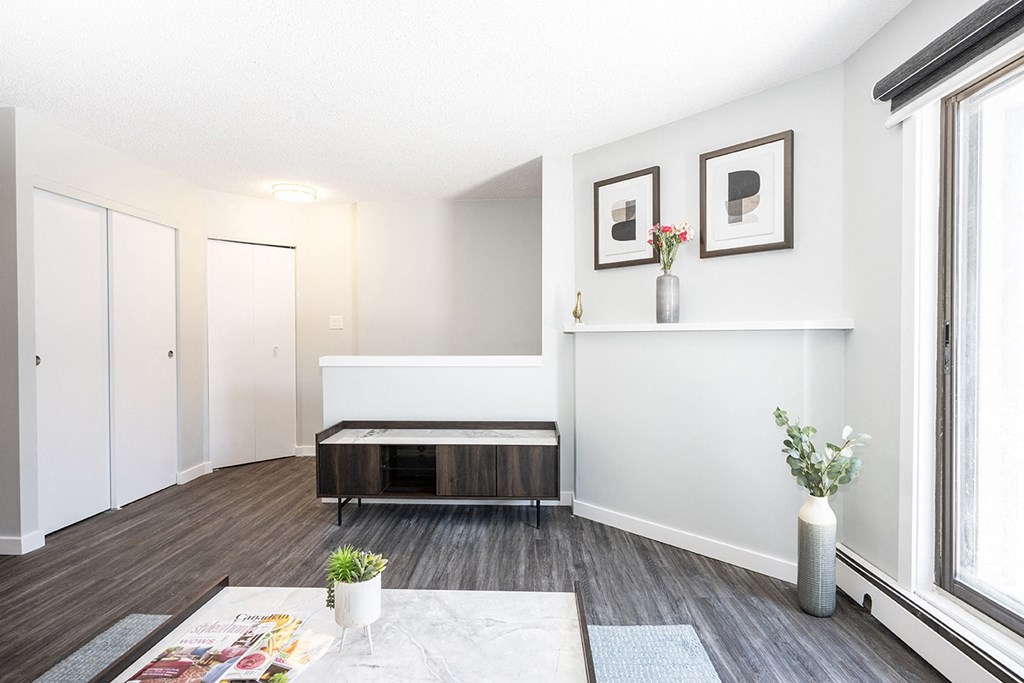 a living room with white walls and a large window