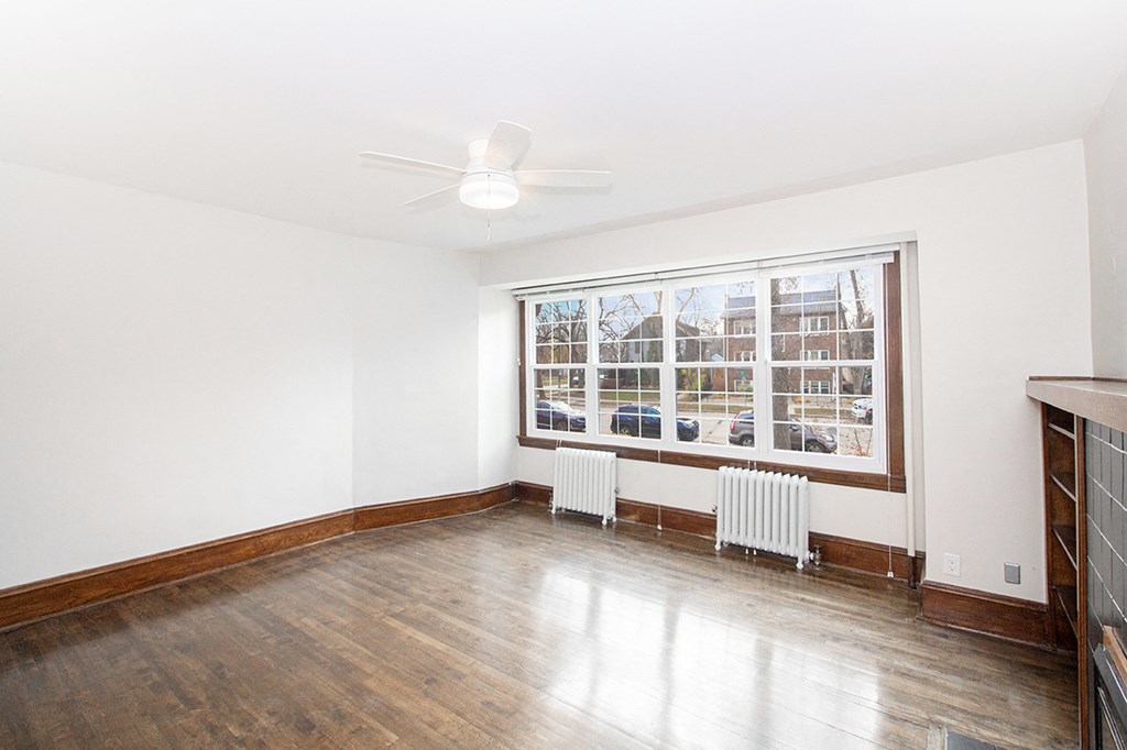 A spacious living room with hardwood floors and a large window at 883 Grosvenor Avenue