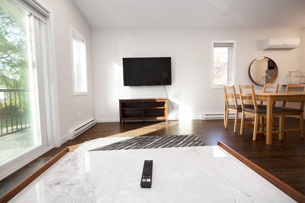 a living room with a tv and a table with chairs
