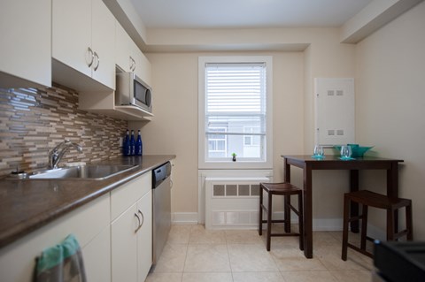 A kitchen with a table and chairs by a window.