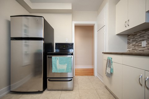 A kitchen with a stainless steel refrigerator and a black dishwasher.