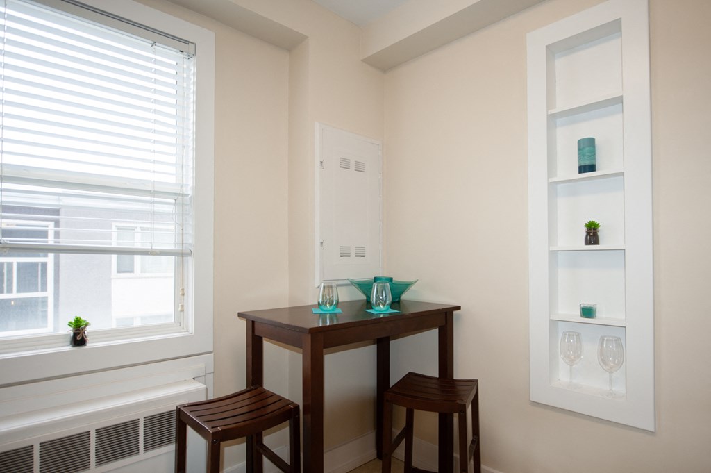 a small table with two chairs in a room with a window