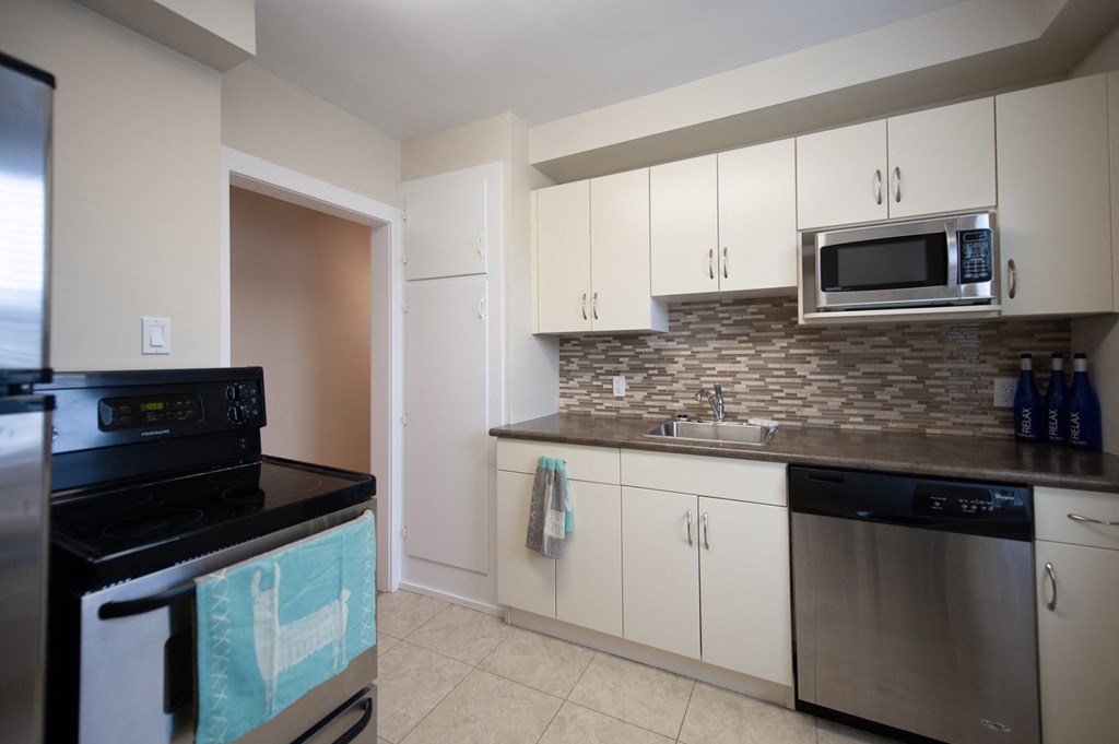 a kitchen with stainless steel appliances and white cabinets