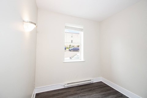 a living room with a window and a hard wood floor