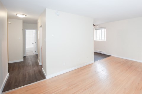 an empty living room with white walls and wood floors