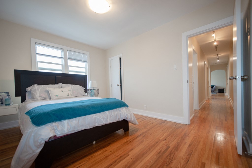 a bedroom with a bed and a hallway with a door to a bathroom