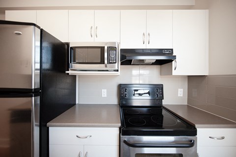 a kitchen with stainless steel appliances and white cabinets