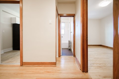a living room and hallway with wood floors and a mirror