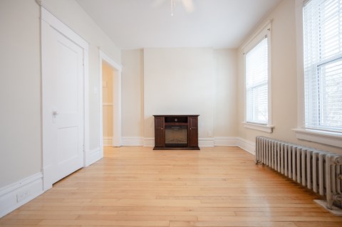 a living room with a wooden floor and a fireplace
