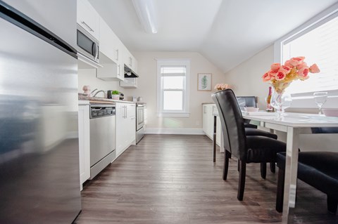 A kitchen with a table and chairs.