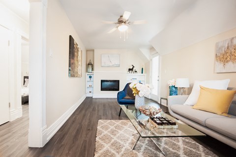A living room with a couch, coffee table, and a painting on the wall.