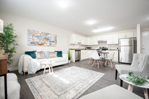 a living room with a couch and a kitchen with a table and chairs