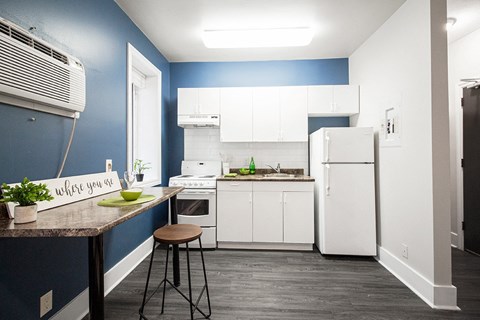 a blue and white kitchen with a counter and a refrigerator