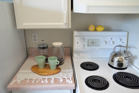 A kitchen with a white stove top and a white oven.