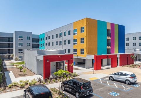 A colorful building with a parking lot in front.
