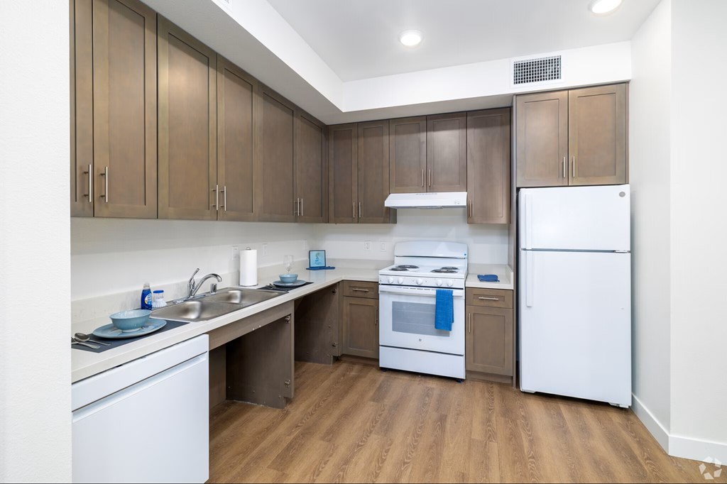 A kitchen with white appliances and wooden cabinets.