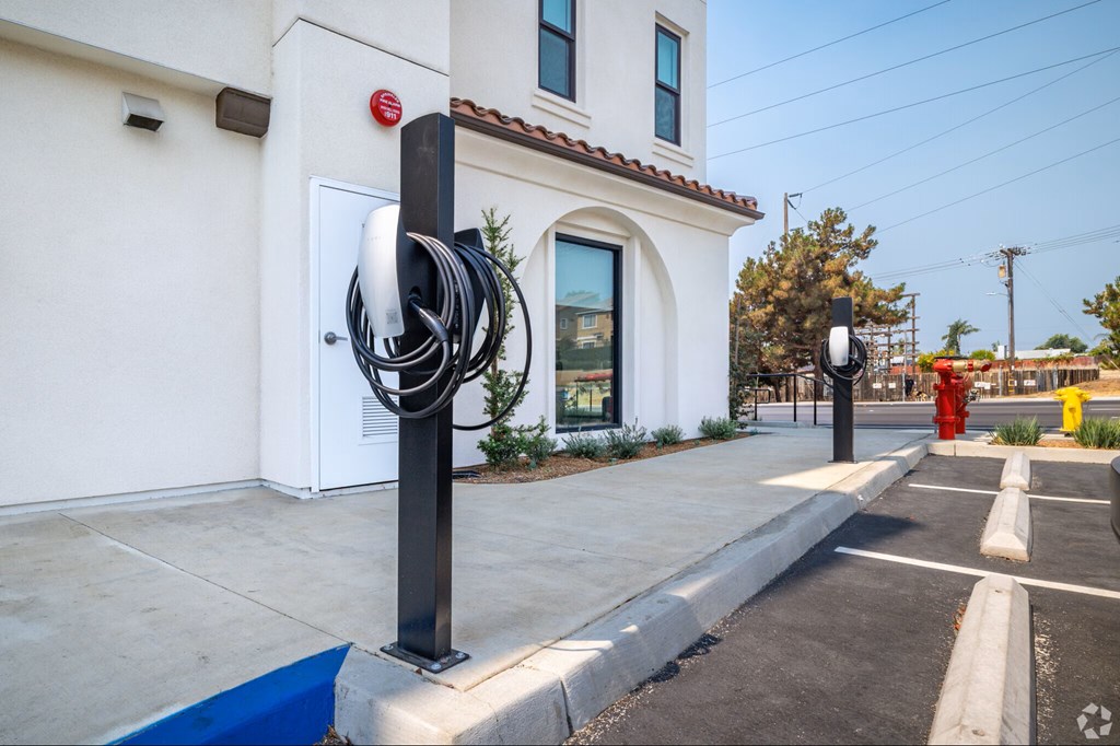 A white building with a red fire hydrant in front of it.