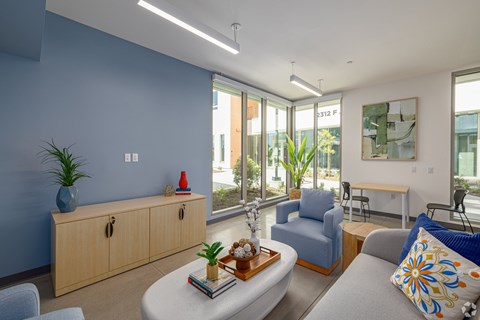 A living room with a blue couch and a wooden coffee table.
