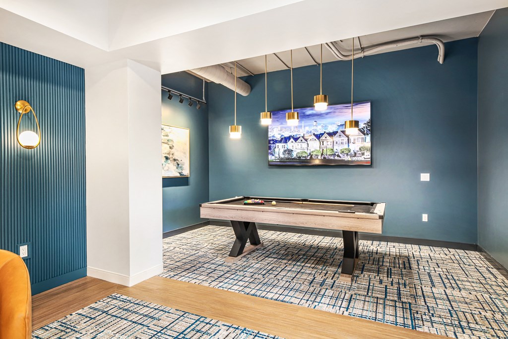 a games room with a pool table and a tv