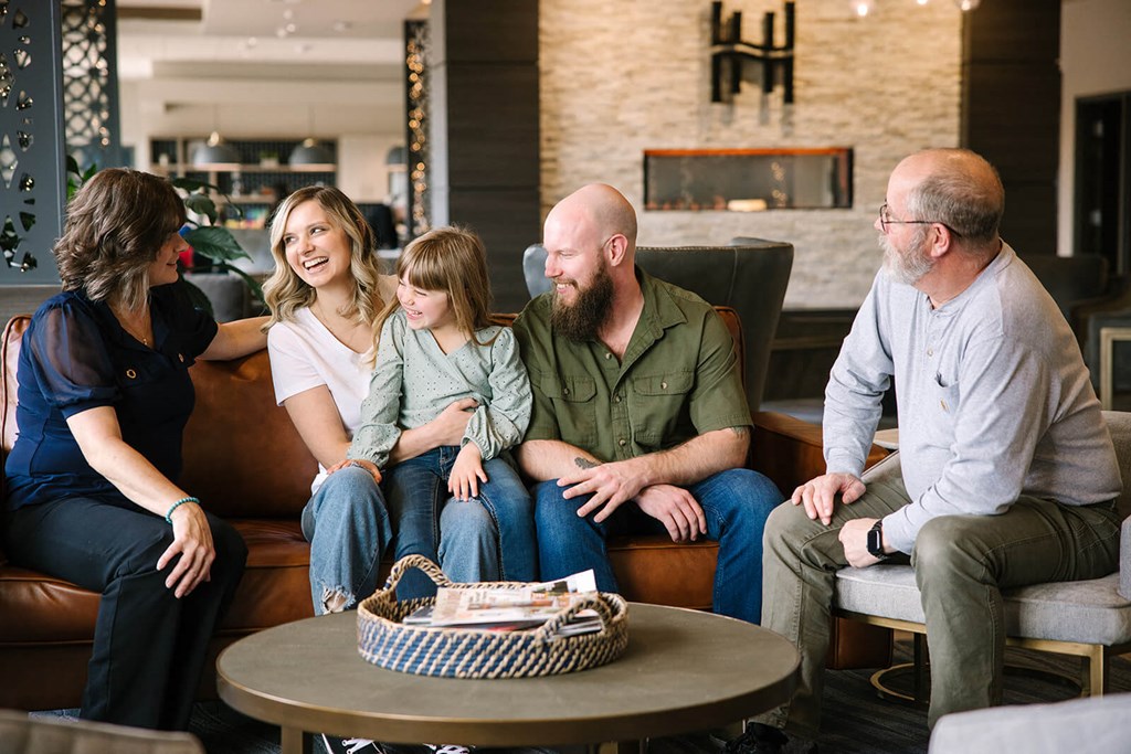 a family sits on a couch in a hotel lobby  at Harbor Heights 55+ Community, Washington