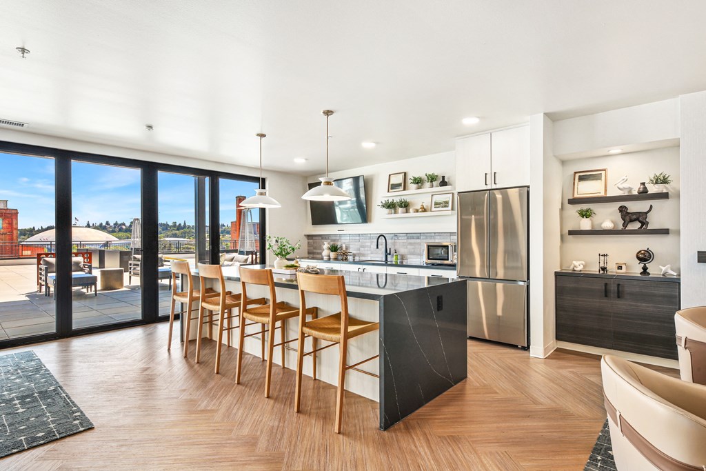a kitchen with a large island with bar stools and sliding glass doors