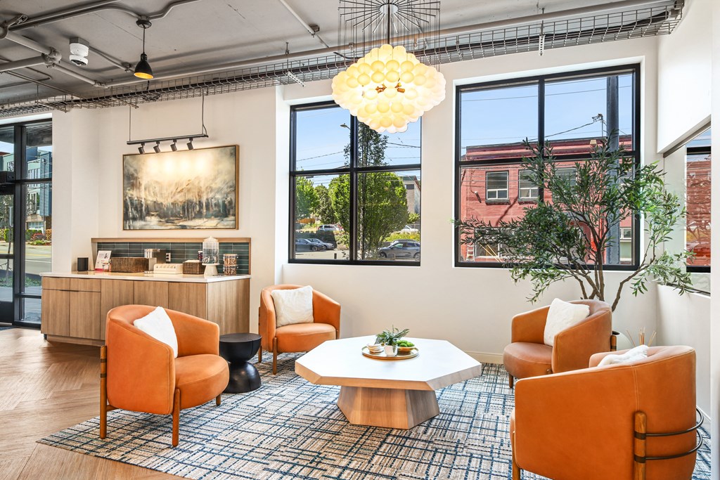 a living room with orange chairs and a white table
