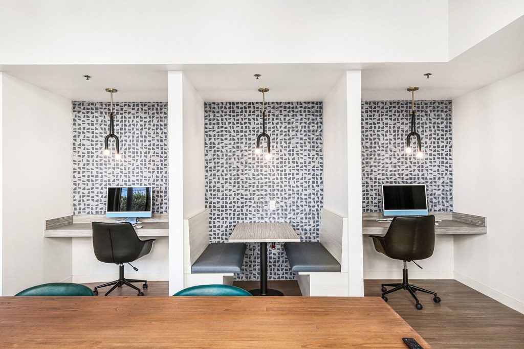 a conference room with desks and chairs and a table with a laptop