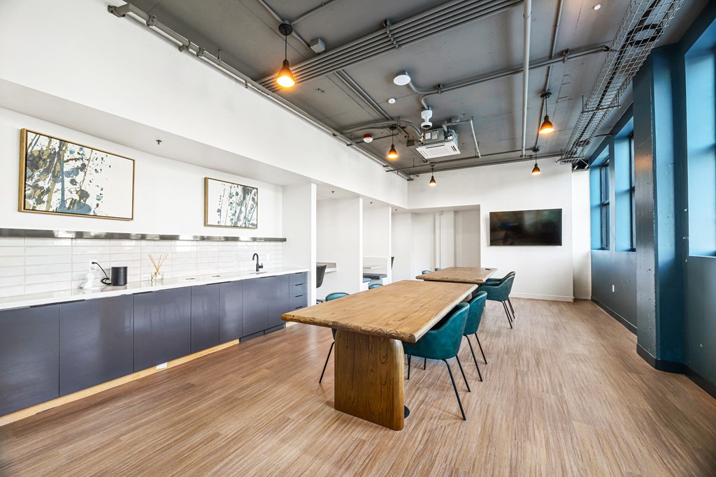 a conference room with a table and chairs and a kitchen