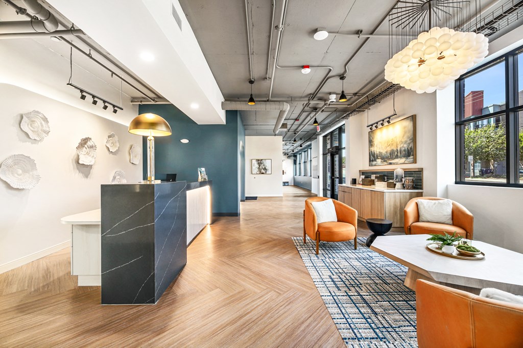 a lobby with a reception desk and chairs and a table