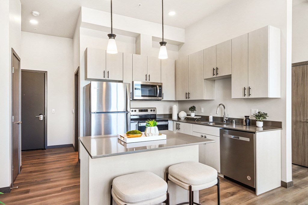 a modern kitchen with stainless steel appliances and white cabinets