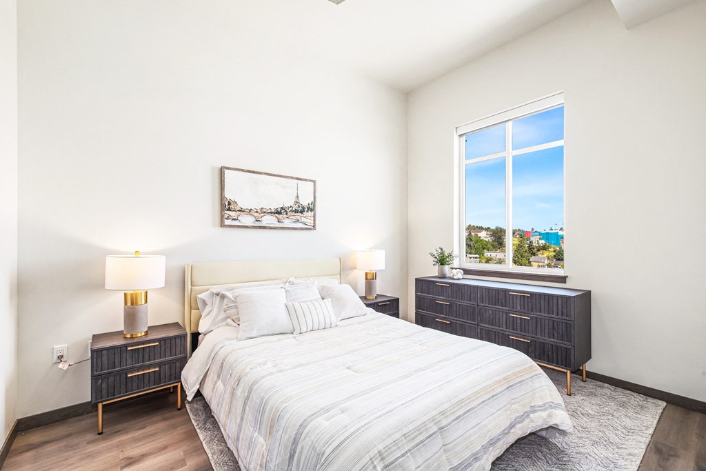 a bedroom with a bed and a large window