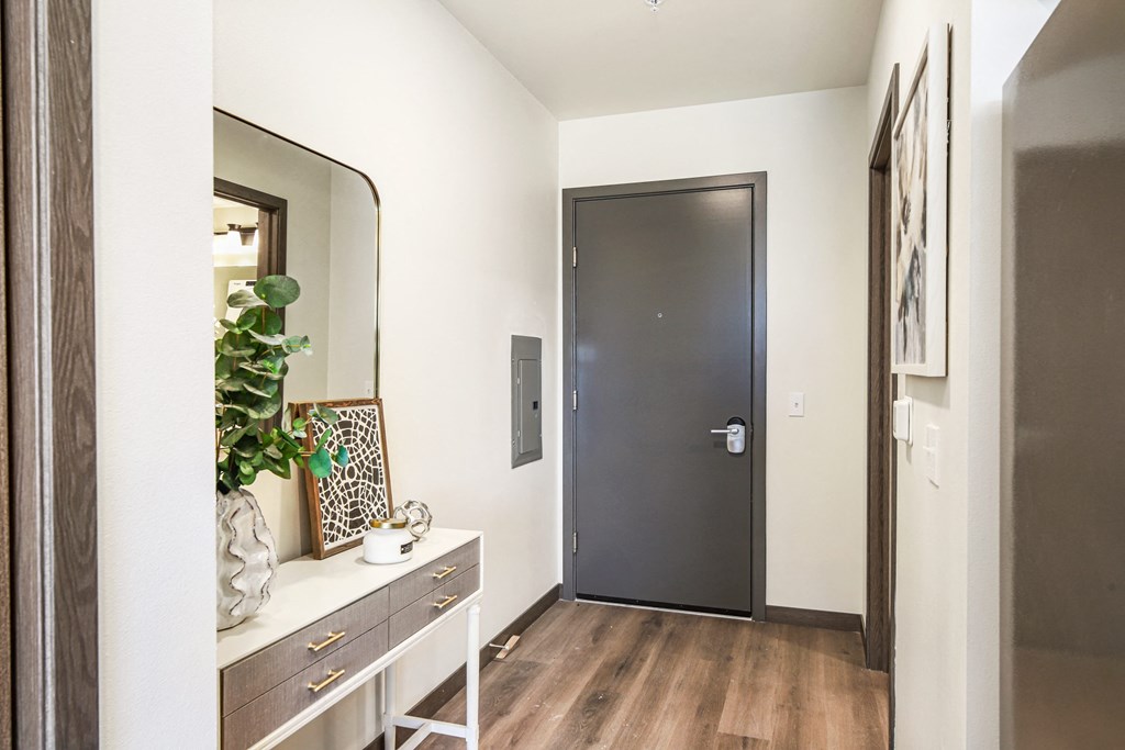 a hallway with a black door and a mirror