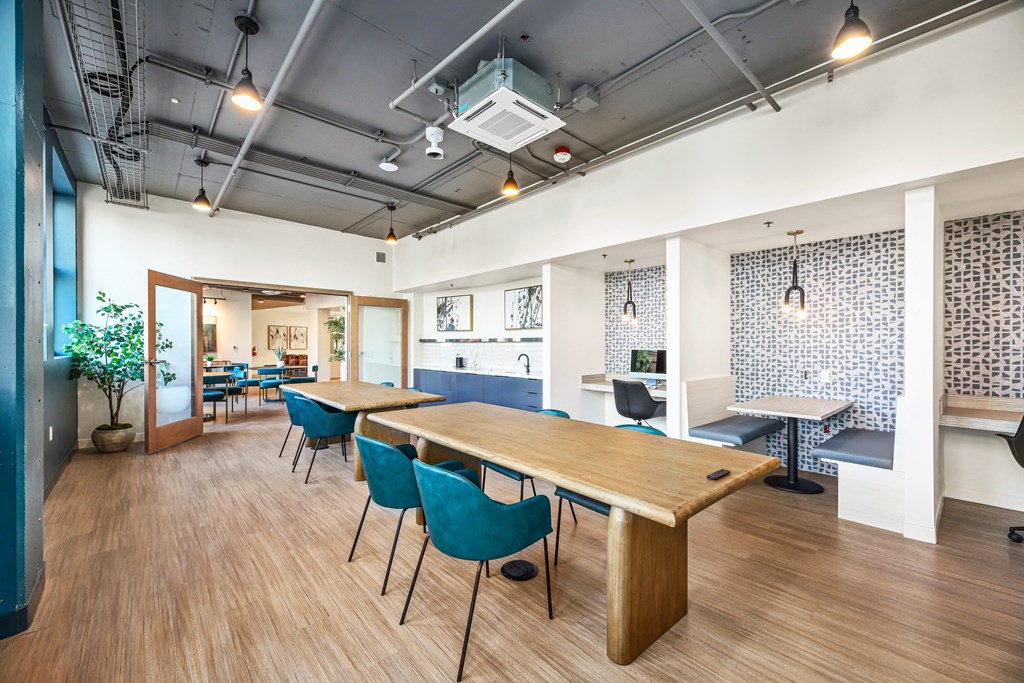 a dining room with tables and chairs and a kitchen
