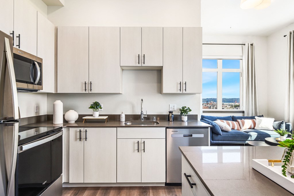 a kitchen with white cabinets and a sink and a window