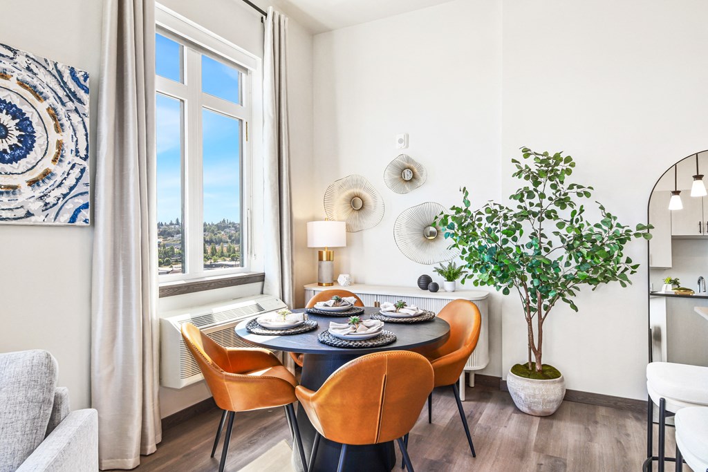 a dining room with a table and chairs and a large window