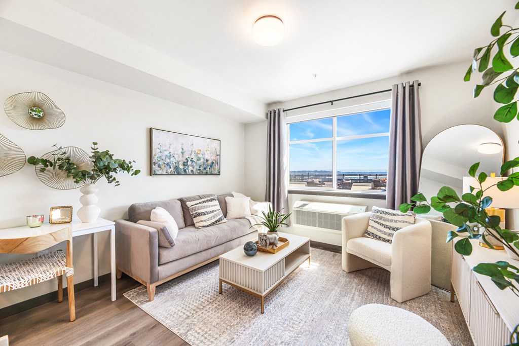 a living room with couches and chairs and a large window