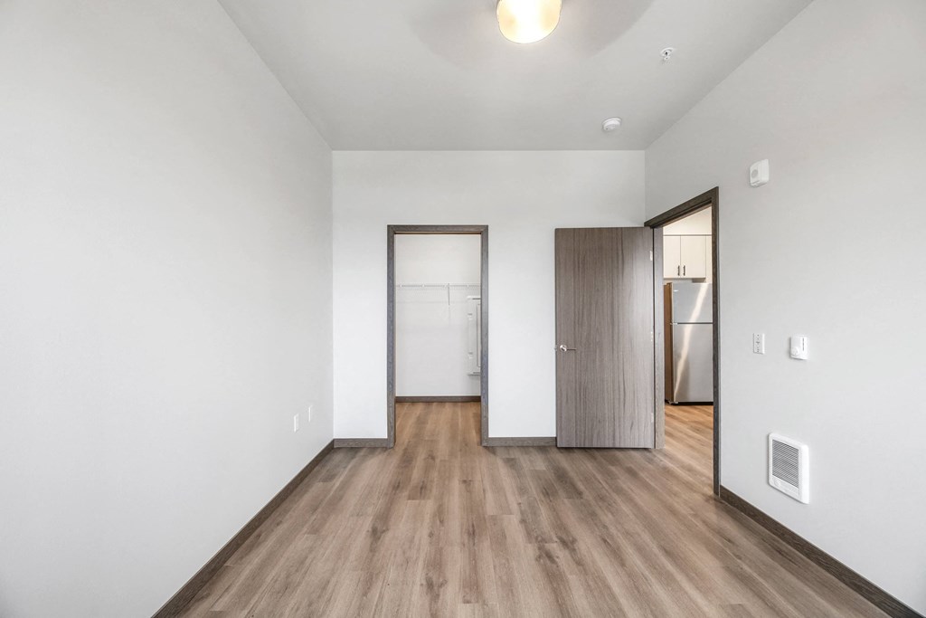 an empty living room with white walls and wood floors