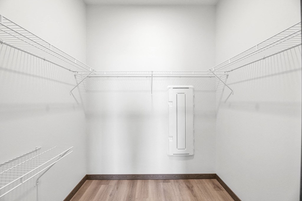 A walk in closet with shelving