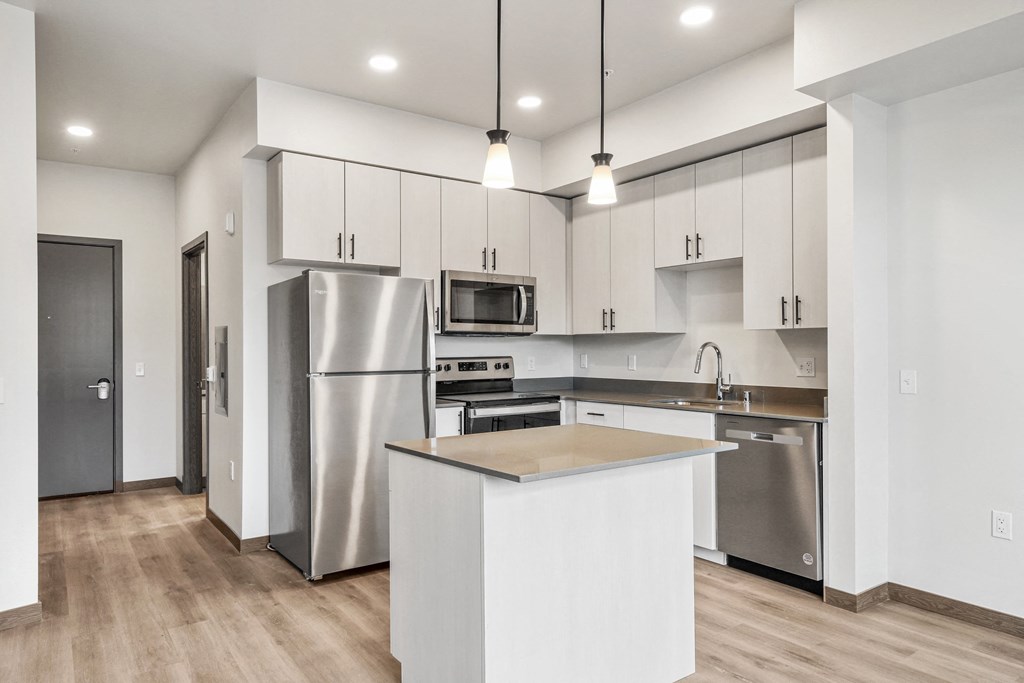 a kitchen with white cabinets and stainless steel appliances