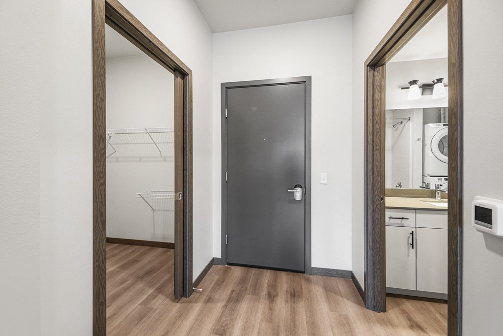 a bathroom with a black door and a laundry room