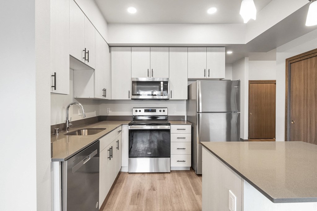 a kitchen with white cabinets and stainless steel appliances