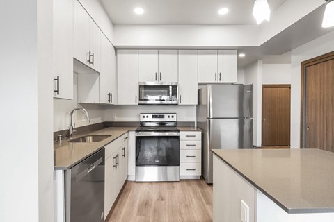 a kitchen with white cabinets and stainless steel appliances