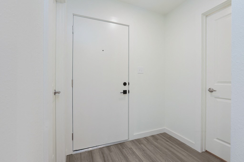 a bedroom with a medium hardwood floor and a white door