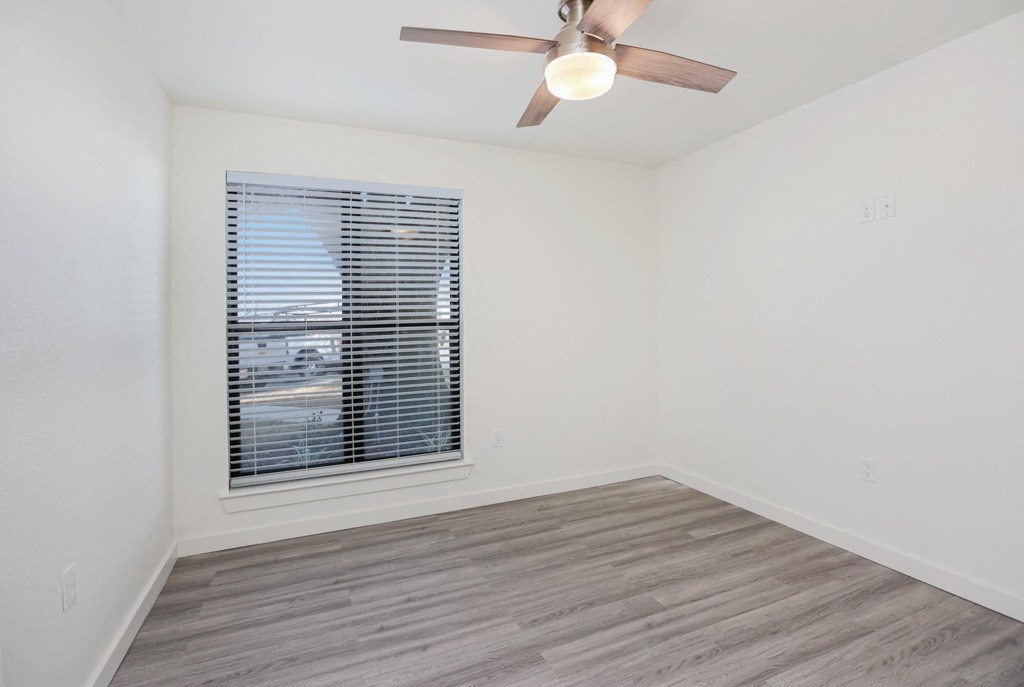 a bedroom with a ceiling fan and a window