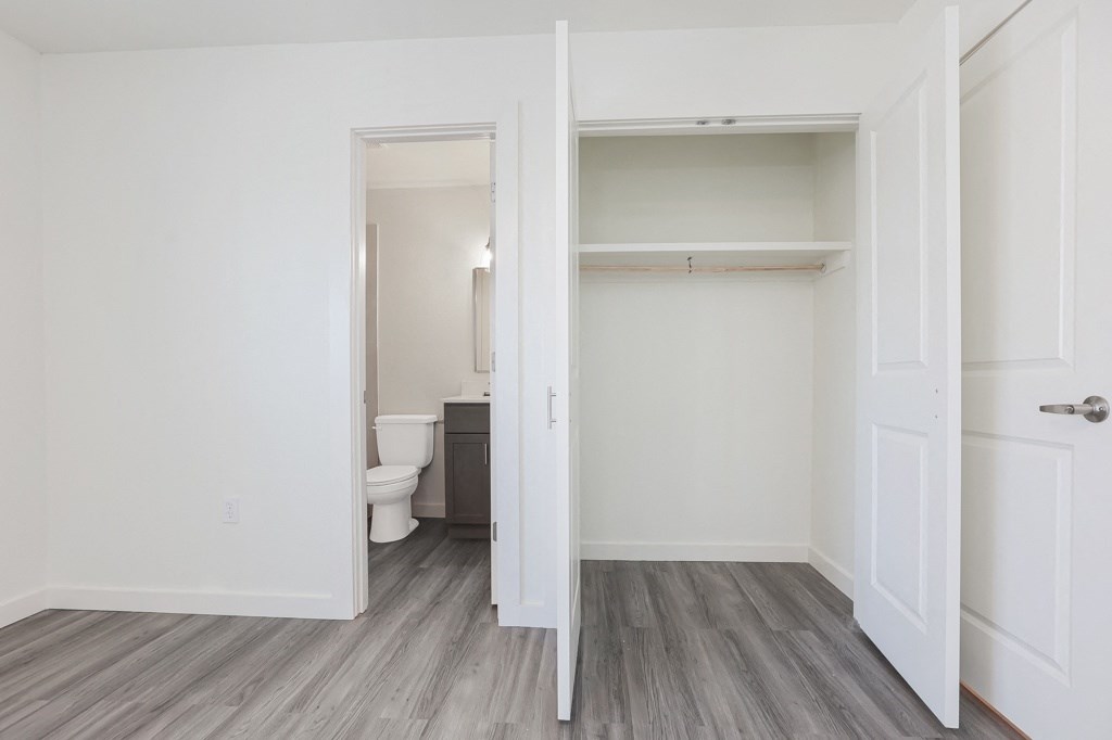 a bedroom in an apartment with a toilet and a closet