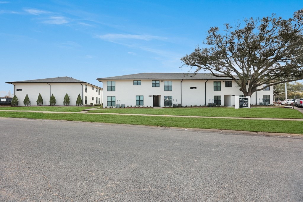 a group of houses on a street with a blue sky in the background