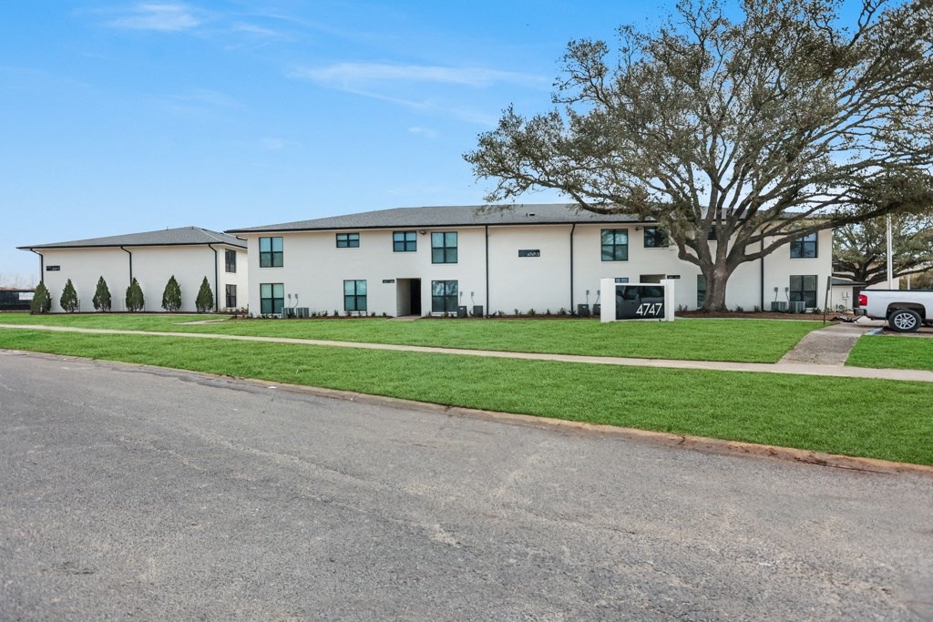 a large white building with a truck parked in front of it