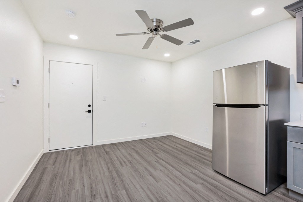 a kitchen with white walls and a stainless steel refrigerator