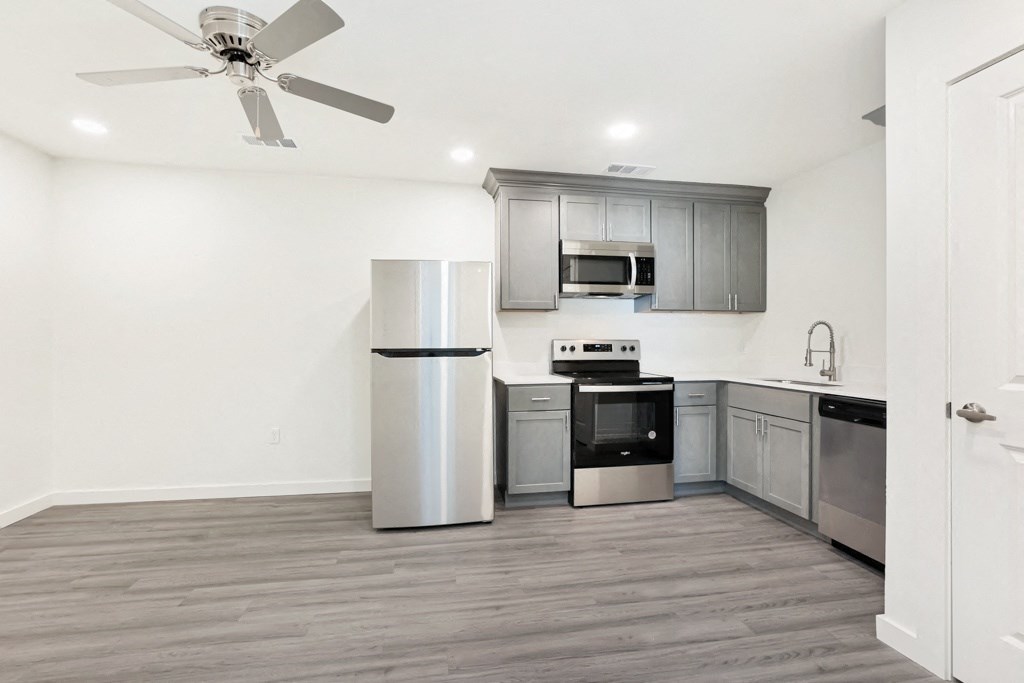 a kitchen with stainless steel appliances and a ceiling fan