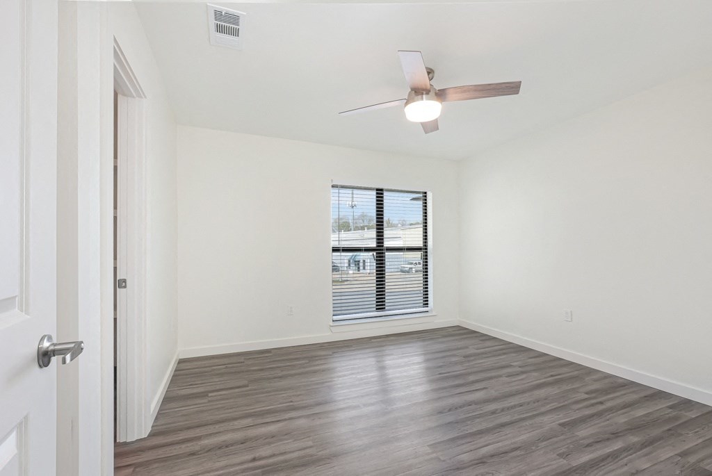 a bedroom with hardwood floors and a ceiling fan